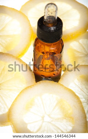 Essential oil amber glass bottle with dropper and some slices of lemon