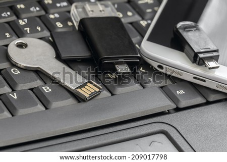 USB  and micro USB flash drives with  smartphone on the laptop keyboard