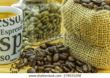 fresh roasted coffee and rest of green bean in small glasses bottle