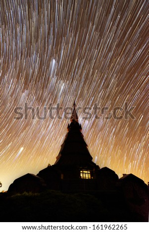 Pagoda silhouette with star trails nature night sky in Thailand.