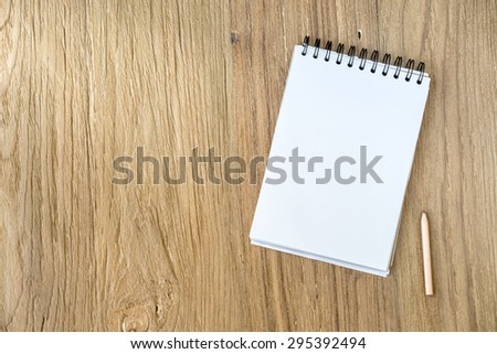 Blank note papers and pencil object on a wooden desk in Top view.