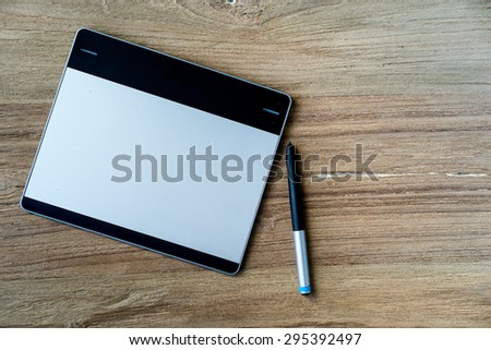 Blank modern digital tablet digitizer object on a wooden desk in Top view.