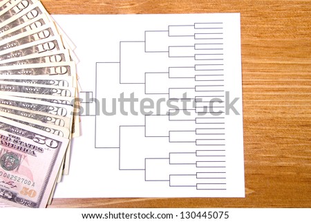 A basketball tournament bracket and fanned money.