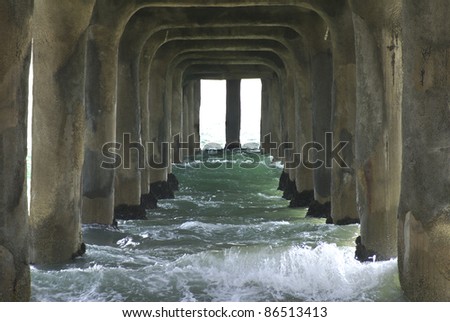 Waves flowing under a concrete pier in California