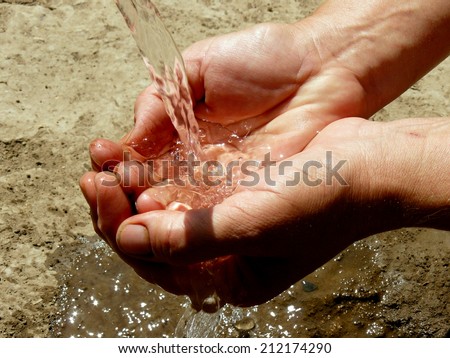 hands catching the stream of water