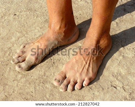 dirty male feet on dried earth