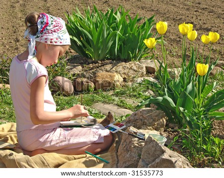 young painter paints near yellow tulips