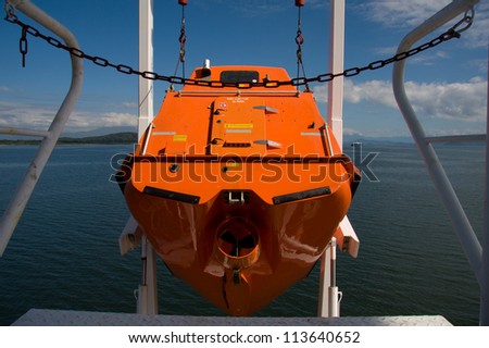 Hoisting ship's free fall life boat after training drill.