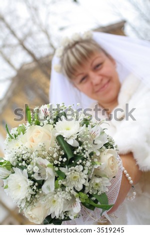 newlywed bride  shows us bouquet of flowers smiling