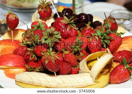 abundance dish of dessert fruits - strawberries, apples, cherry, banana,