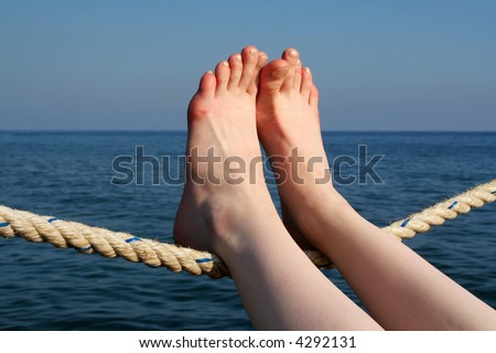 perfect woman feet laying on sail rope