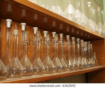 shelf with row of empty chemical flasks
