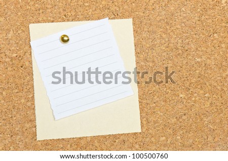 Two memo note papers pinned to a cork bulletin board with a brass tack.