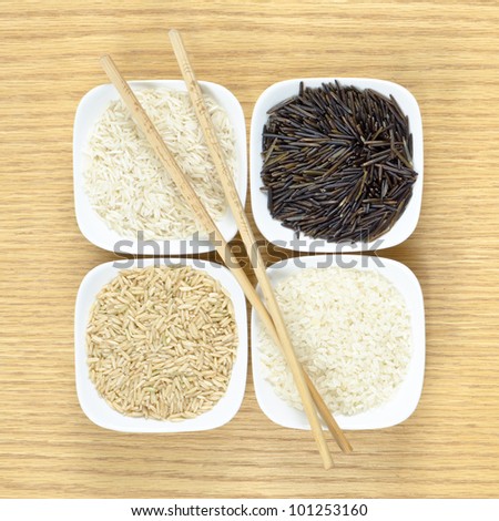 Wild rice, brown rice and short and long grain rice with chopsticks.