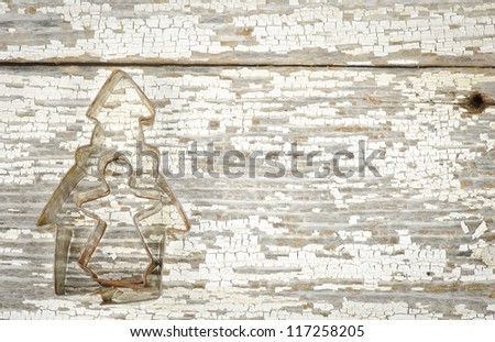 A church and an angel cookie cutter on a weathered board in a horizontal format
