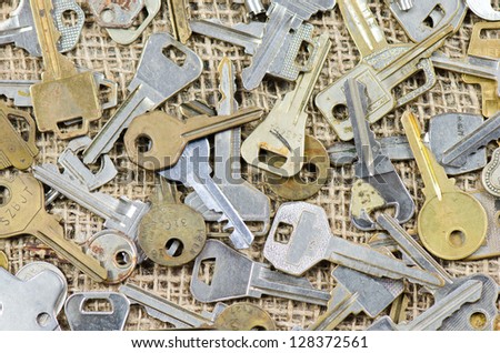 Keys scattered on a burlap surface.