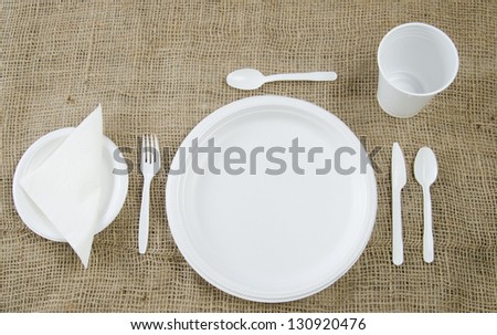 Place setting of disposable dinnerware on a burlap covered table