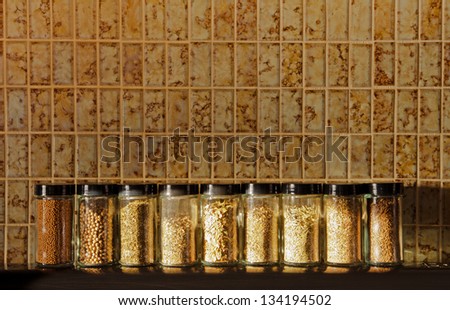 A row of spice jars with moody lighting from the late afternoon sun with a vintage look