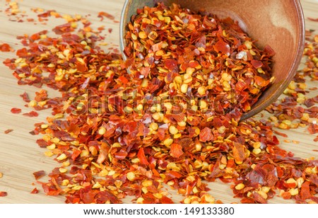 Crushed red hot peppers spilling from a bowl