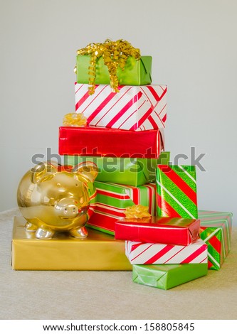 A piggy bank and a pile of presents representing the expense of Christmas or money as a gift