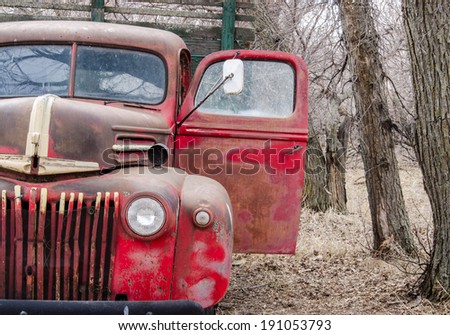 An old  farm truck abandoned in some trees