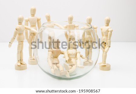 Life in a fishbowl concept with wooden artist mannequins