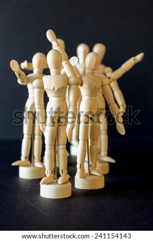 A group of artist manikins with arms raised to signify anger, cheering, waving or joy