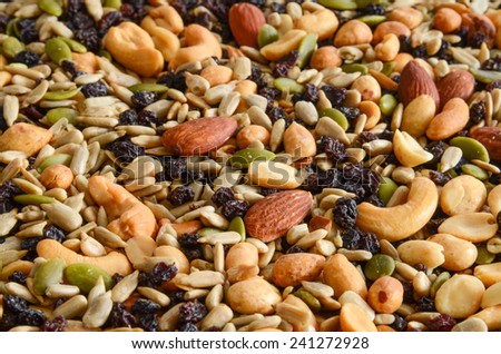 A background of trail mix with nuts , seeds and currants