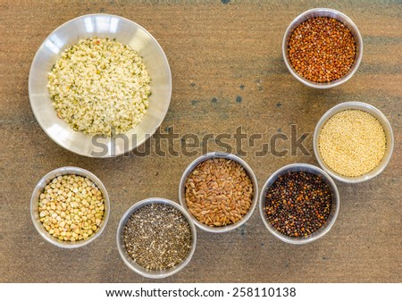 Ancient grains and healthy organic edible seeds in round stainless steel containers