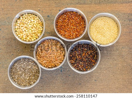 Ancient grains and healthy organic edible seeds in round stainless steel containers