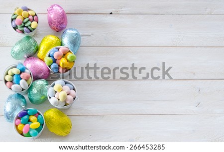 Colorful Easter candies on a rustic wood white background