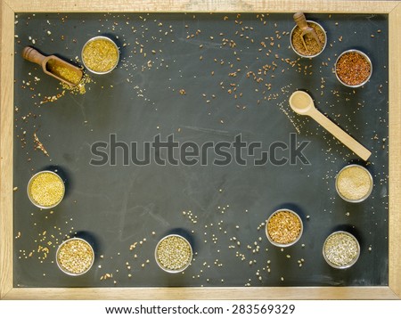 Ancient grains in metal containers on a blackboard in late afternoon light