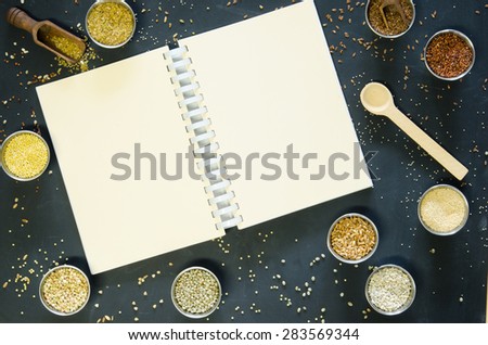 Ancient grains and gluten free alternatives on a black board surface with a coil bound book for your text