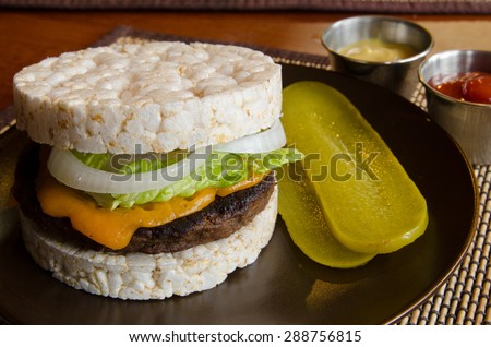 An alternative hamburger made with rice cakes for gluten free diets, with cheese, ketchup, mustard and fixings