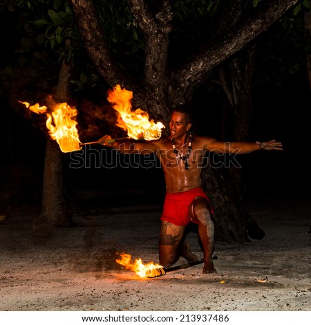 TAHAA, FRENCH POLYNESIA - CIRCA 2014: Polynesian man perform traditional fire dance circa 2014 in Tahaa. Fire dance is popular tourist attraction on luxury resorts of French Polynesia.