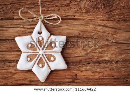 Gingerbread snowflake hanging over wooden background