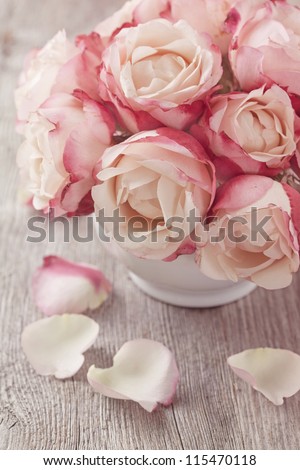 Pink roses and petals on wooden desk