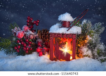 Burning lantern in the snow at night