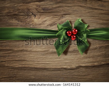 Green christmas bow on a wooden background