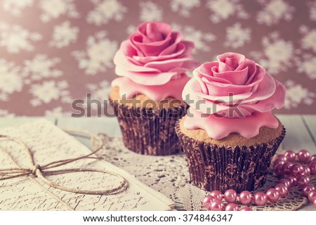 Cupcakes with sweet rose flowers and a letter