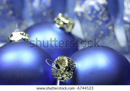 Blue christmas balls with a curly golden blue ribbon in snow