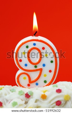 Number nine birthday candle on orange background