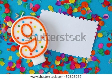 Number nine birthday candle on blue background