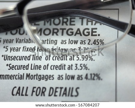 Eyeglasses over mortgage rates ad in a newspaper
