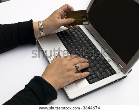 Shopping over the Internet, female hands holding credit card and typing order on a laptop keyboard
