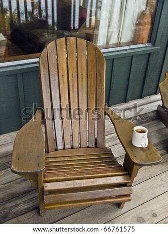 Old wooden chair and cup of coffee on a deck of a lodge