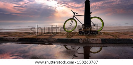 a bicycle at a beach with reflection and ray of light