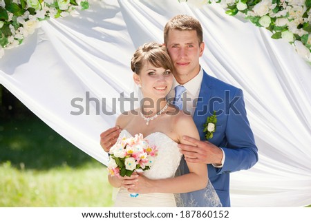 happy wedding couple posing for photographer after outdoors wedding ceremony