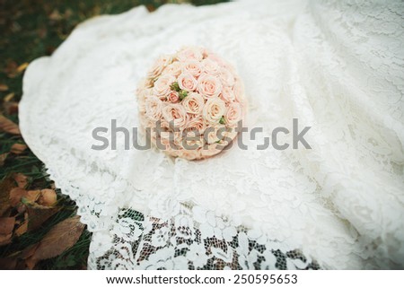 Wedding bouquet of flowers on fabric of wedding gown of bride. No people. Wedding decor