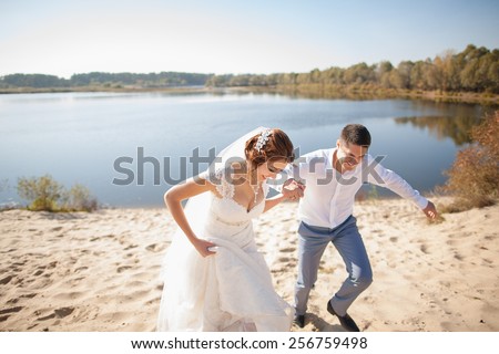 honeymoon of just married wedding couple. happy bride, groom standing on beach, kissing, smiling, laughing, having fun on beach. lovers happy young people in love. lifestyles. woman man